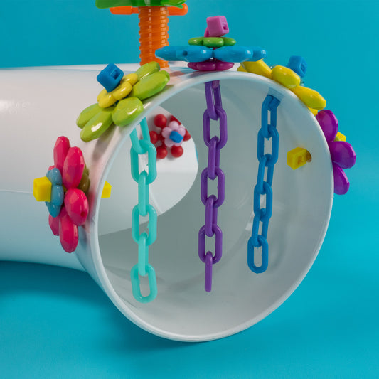 Colorful bird toy with chains and floral decorations on a blue background