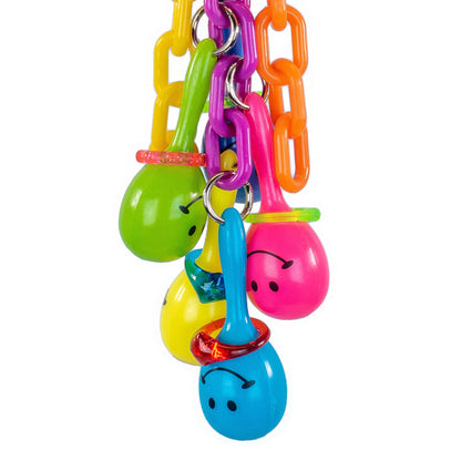 Close up of a colorful bird featuring plastic chain and colorful maracas with smiley faces on them.