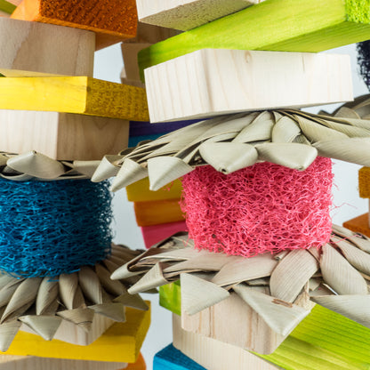 Colorful bird toy with wooden elements, palm leaf, and loofah.