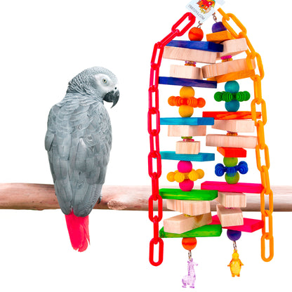 Gray parrot perched on a branch next to a colorful bird toy on a white background
